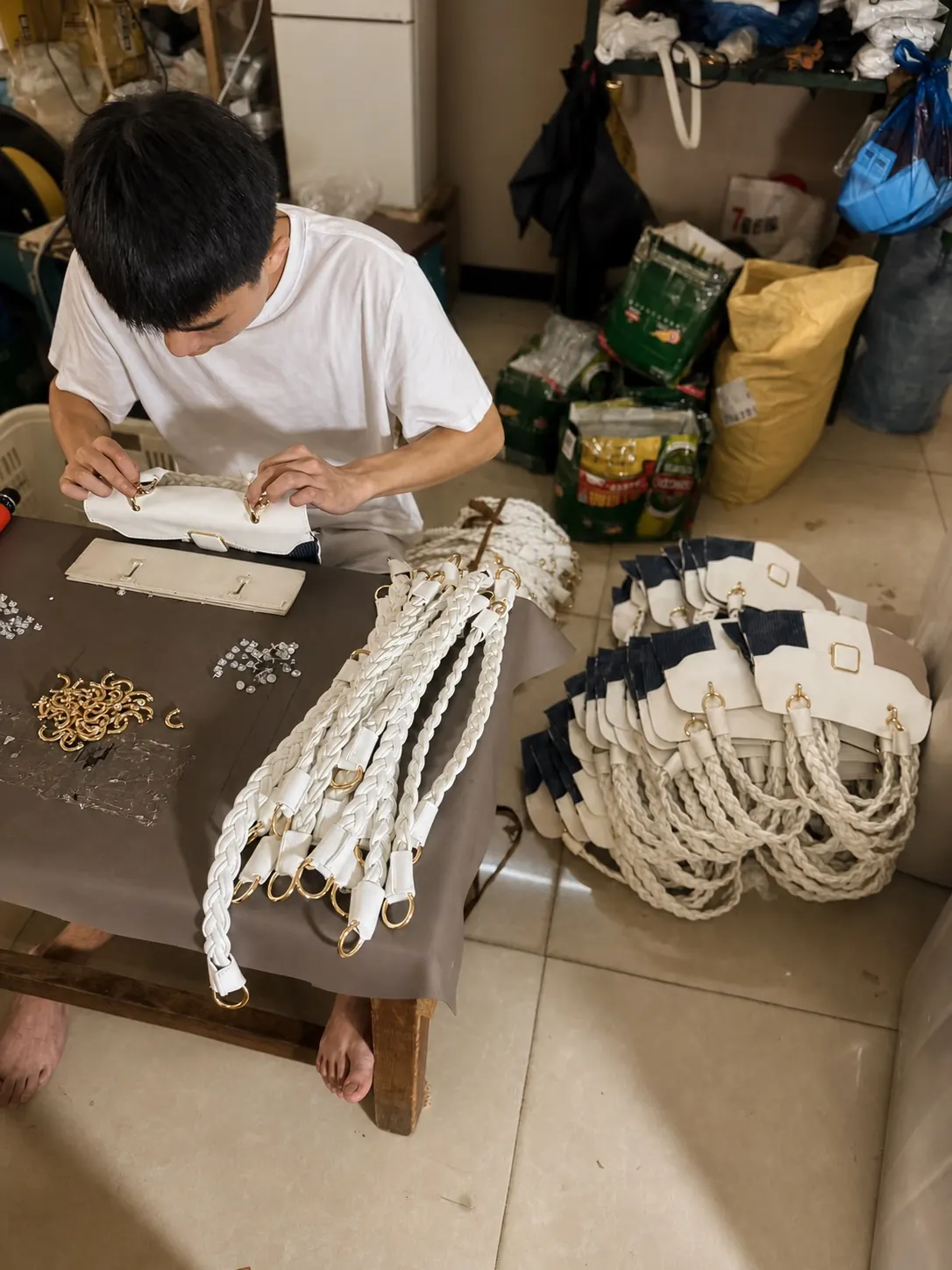 Prepared braided handles and handbag panels during private label bag assembly